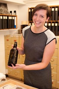 University of Victoria Archaeology professor Katherine Cook holds an Australian beer bottle recovered from a Victoria construction site. The bottle was featured in Bridging Victoria: Stories from the Archaeological Past.   one-off show featured artifacts recovered from construction sites in the city.