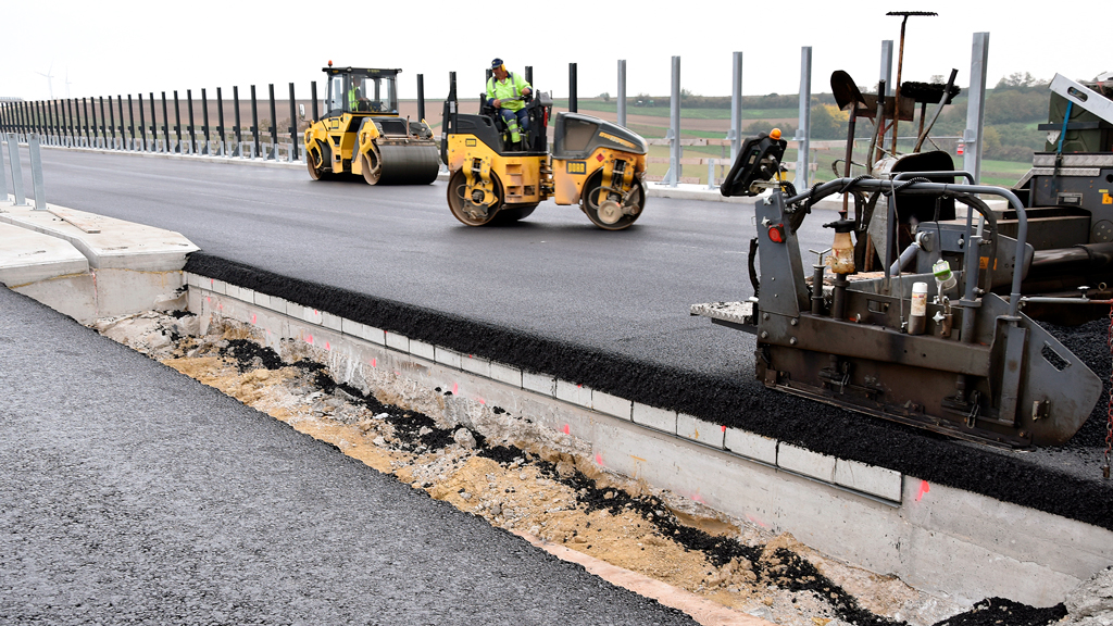 Compactors at work on the asphalt overlay on the Satzengraben bridge in Austria. The series of concrete elements beneath the asphalt are visible in the cut-out.