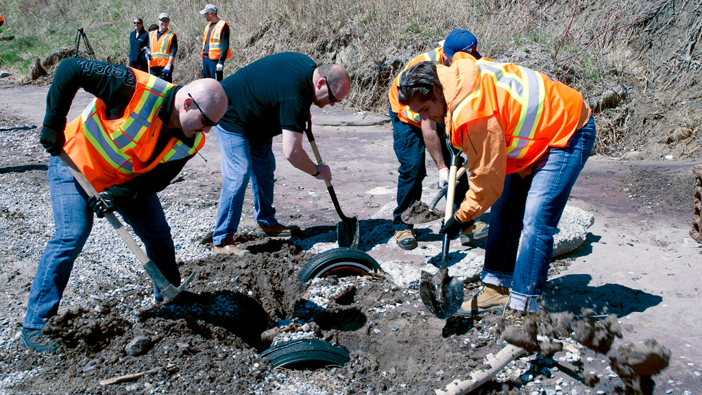 Crews involved in the shoreline cleanup unearthed a car axle. Volunteers dug around the part in order to make it easier for the ATV to pull it out before it was loaded onto a boat for removal.