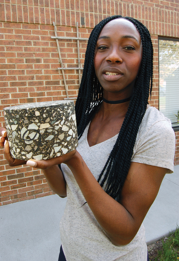 Amma Wakefield displays a sample asphalt mix briquette, which is made in a laboratory mixing aggregates and asphalt and then compacting it. This sample would be tested and, if it meets volumetric and strength properties, would be approved for production and placement on a road. Wakefield is the Asphalt Institute’s first full-time Canadian regional representative.