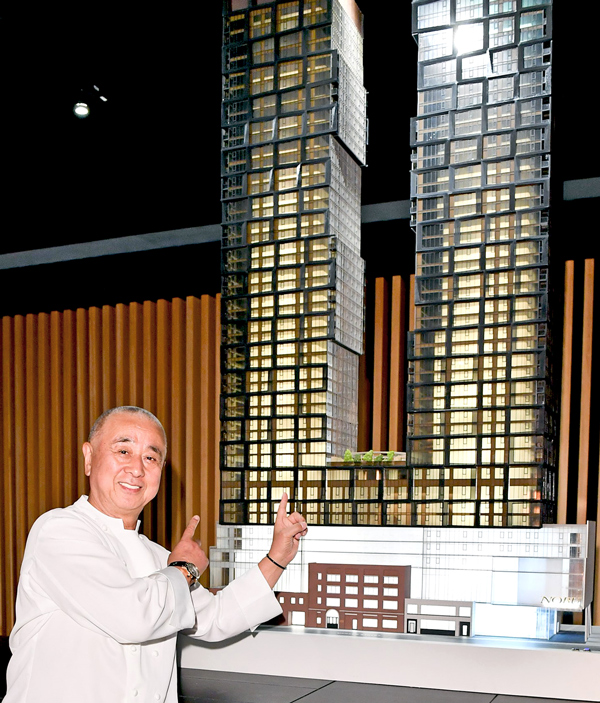 Nobu Hospitality principal Nobu Matsuhisa posed in front of a model of Nobu Toronto.
