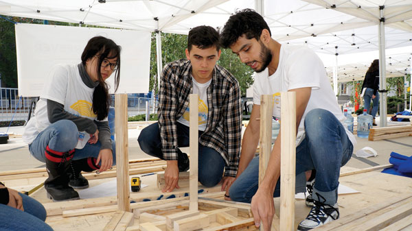 Ryerson architectural student Abhishek Wagle (right), shares assembly ideas with David Moore, a structural engineering student at McMaster University and Lie Zhenkok, a Ryerson engineering student.