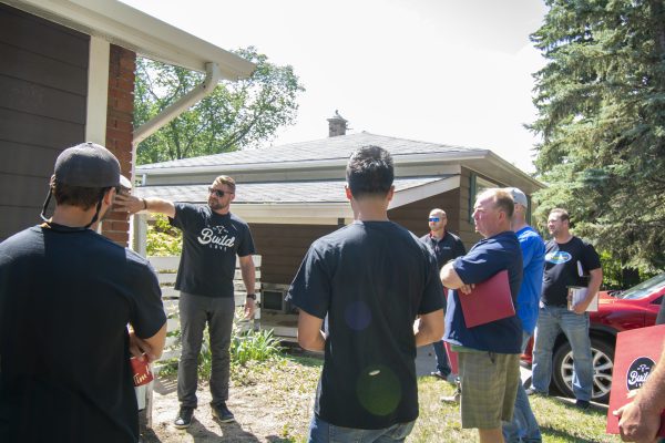 Construction crew members from Build Love, a Saskatchewan volunteer organization, take a look at what they can do for a home renovation.