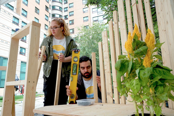 Teodora Nikolic and Arash Ghafoori, Ryerson architectural science students, construct a parklet at TimberFever 2019.