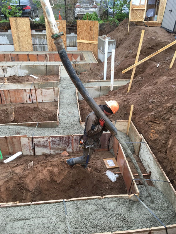 A worker from Tri-Star Forming oversees a pour at the Habitat Hamilton site on Catharine Street North in Hamilton. The duplex project has been adopted by the Hamilton-Halton Construction Association as its 100th-anniversary Legacy Build.