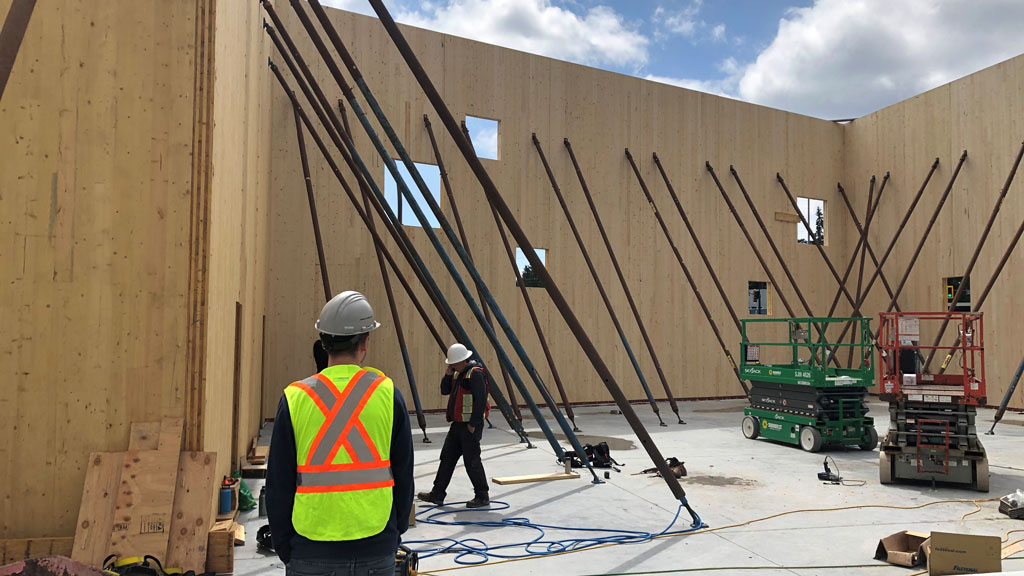 Panels were manufactured off-site for the Langford, B.C. warehouse project. When they arrived via truck they were lifted by a large crane and fitted into position by workers. Conventional wood framing was also used in the construction of the warehouse. Five-ply mass timber panels were constructed running vertically.